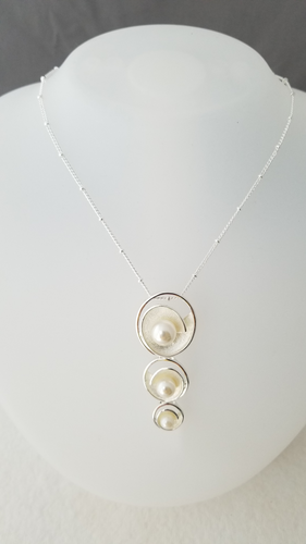 Triple station necklace with pearls ranging from large to small nestled in silver swirls. With 18in  beaded cable chain and 4in extender